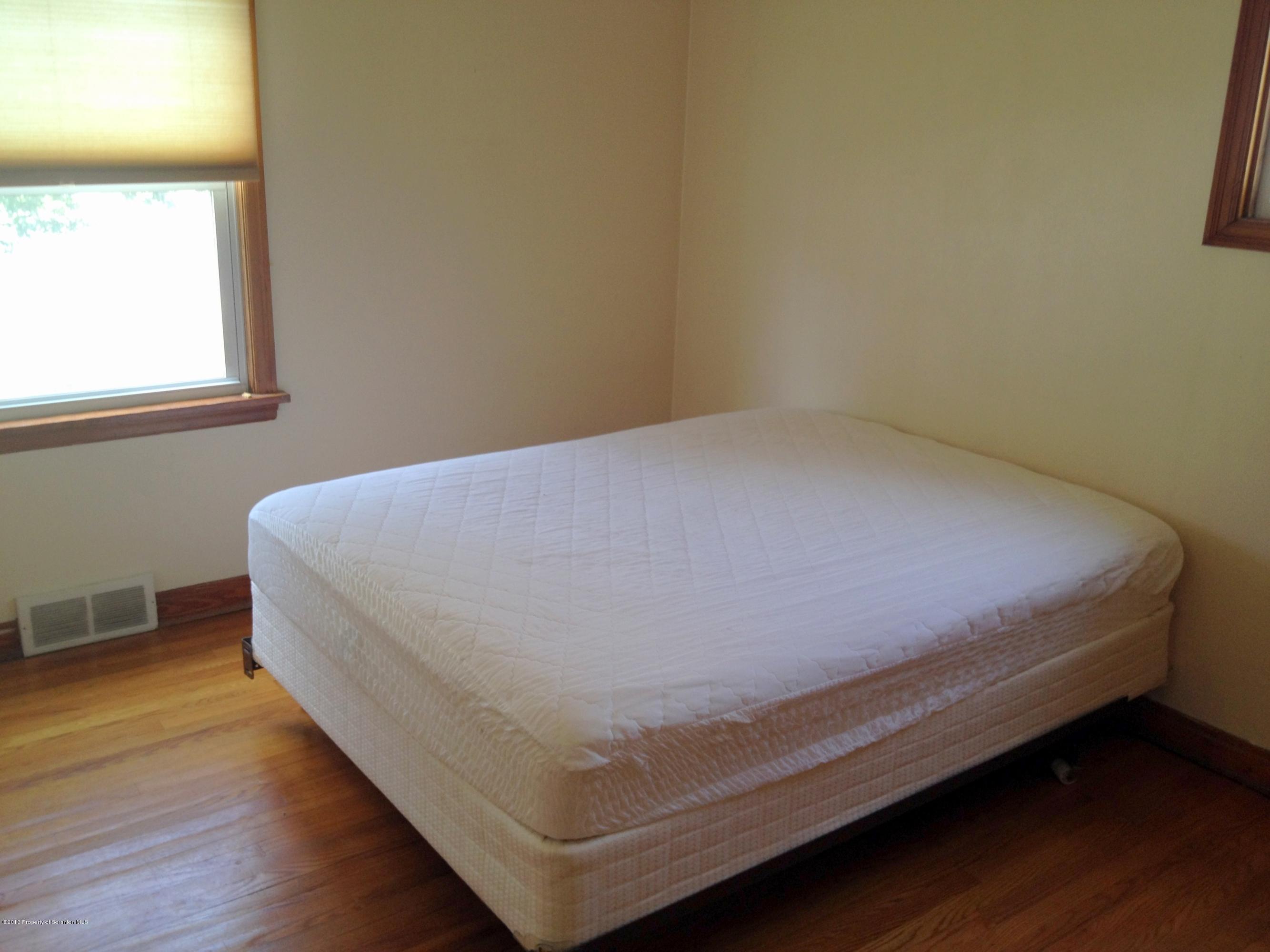 125 Corcoran Street Old Forge, PA 18518 - Photo 14 of 36 a bed sitting in a bedroom next to a window