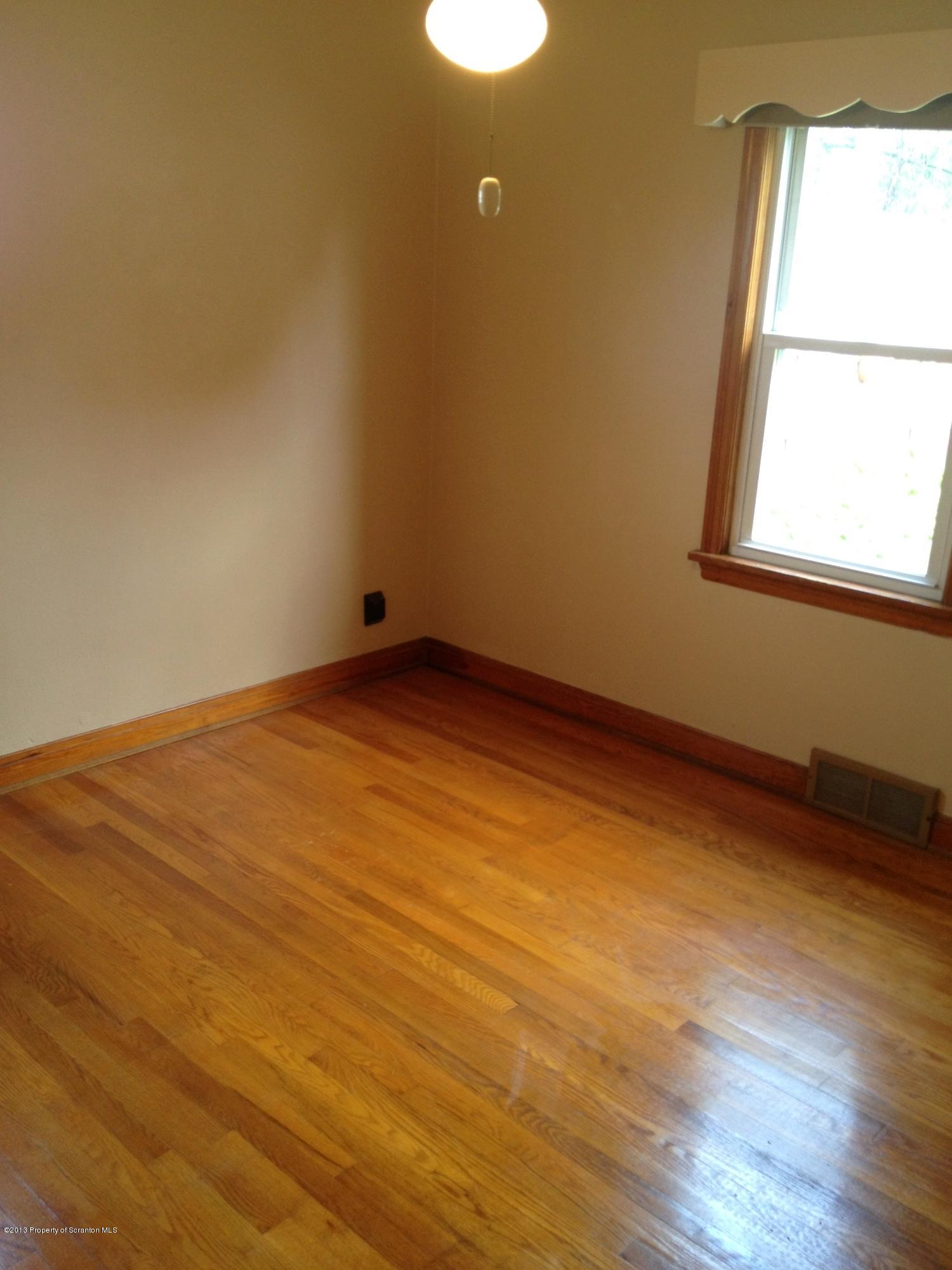125 Corcoran Street Old Forge, PA 18518 - Photo 16 of 36 an empty room with wooden floor and windows