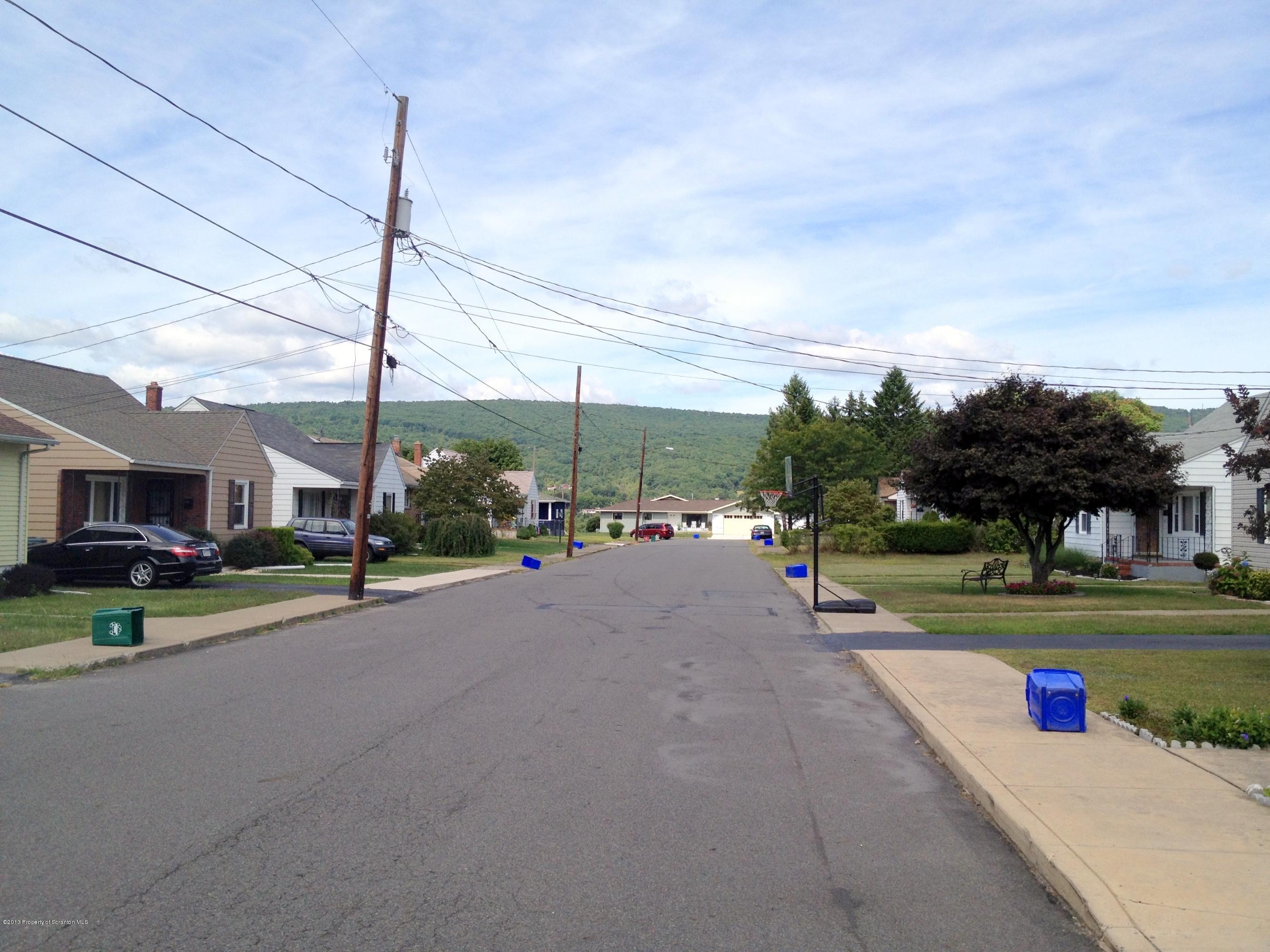 125 Corcoran Street Old Forge, PA 18518 - Photo 34 of 36 a view of a road with a building and cars park