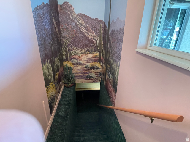 438 East Main Street Elsinore, UT 84724 - Photo 35 of 43 Stairwell featuring a desert landscape mural, carpeted stairs, and a light wood handrail