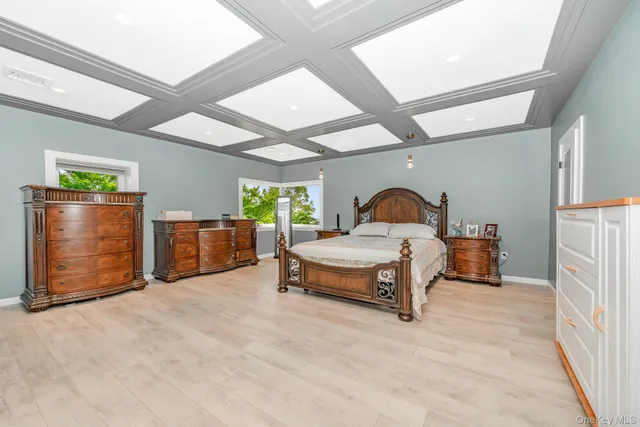 a spacious bedroom with a bed and a dresser next to a window