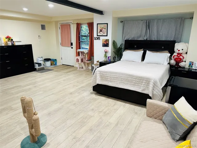 a bedroom with a bed and wooden floor