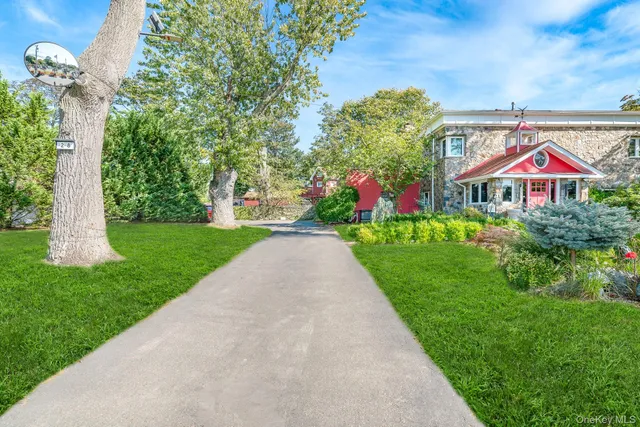 a front view of a house with a yard and potted plants