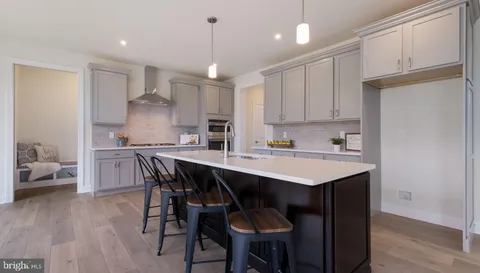 a kitchen with a sink a center island stainless steel appliances and cabinets