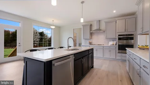 a kitchen with kitchen island granite countertop a sink appliances cabinets and a counter top space