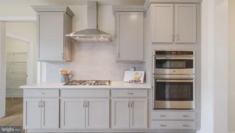 a kitchen with white cabinets and appliances
