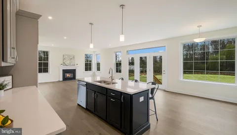 a dining hall with stainless steel appliances granite countertop a sink a counter space and a view of kitchen