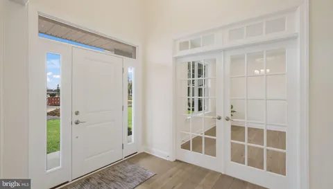 an entryway with wooden floor and cabinet