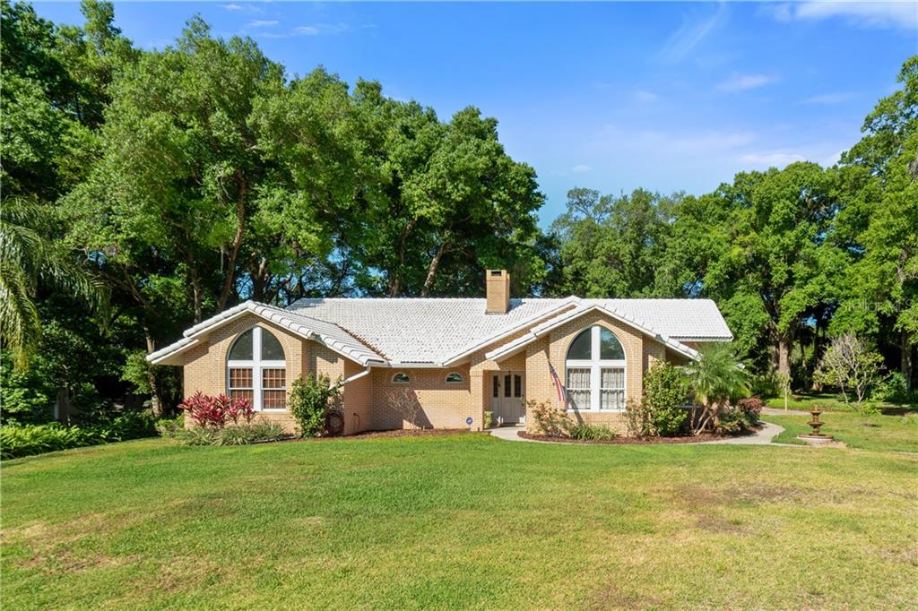 a house with a big yard and large trees