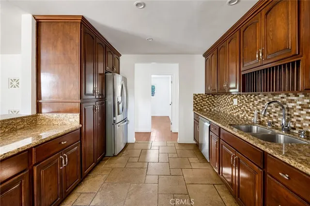 a kitchen with stainless steel appliances granite countertop a refrigerator and a stove top oven