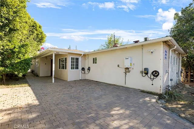 a view of a white house with a big yard and large tree