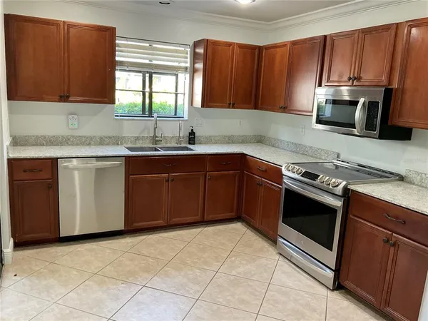 a kitchen with stainless steel appliances granite countertop a stove microwave and sink