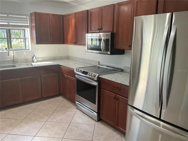 a kitchen with stainless steel appliances granite countertop a refrigerator stove a sink and dishwasher