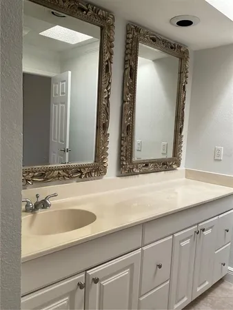 a bathroom with double vanity sinks and a mirror