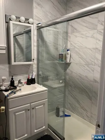 a bathroom with a sink vanity and shower