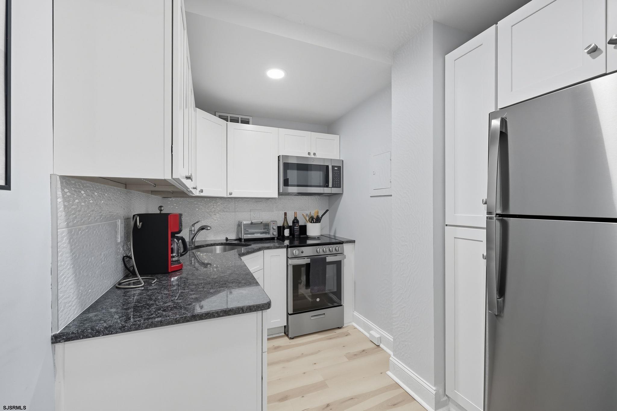 101 South Raleigh Avenue, Unit 809 Atlantic City, NJ 08401 - Photo 18 of 40 a kitchen with a refrigerator a stove top oven a sink and dishwasher