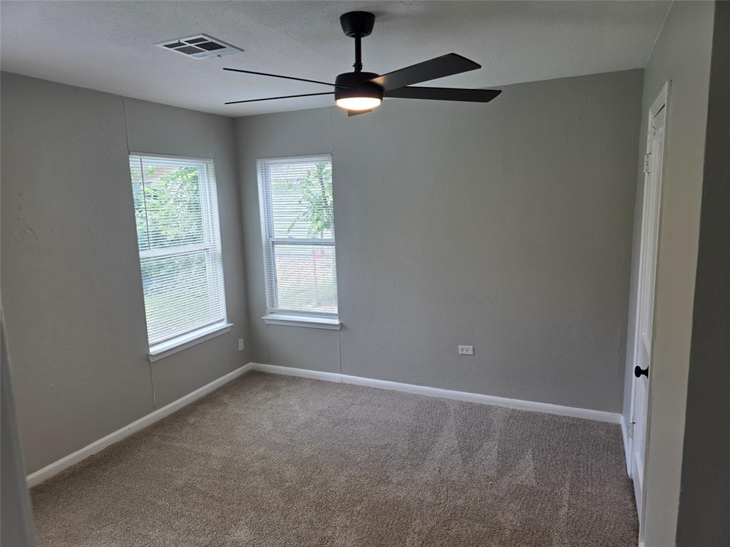 2804 Summer Avenue Waco, TX 76708 - Photo 8 of 13 Carpeted room featuring two double-hung windows with blinds, a ceiling fan with integrated lighting, a ceiling vent, and a white interior door with a black knob