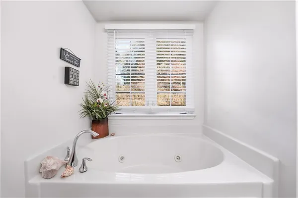 a white bath tub sitting in a bathroom next to a window