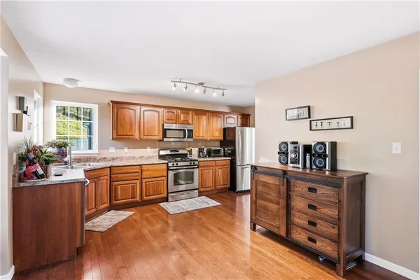 a kitchen with stainless steel appliances kitchen island granite countertop a stove and cabinets