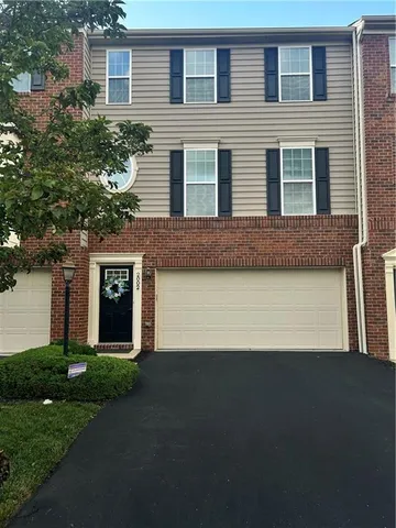a front view of a house with a garden and yard