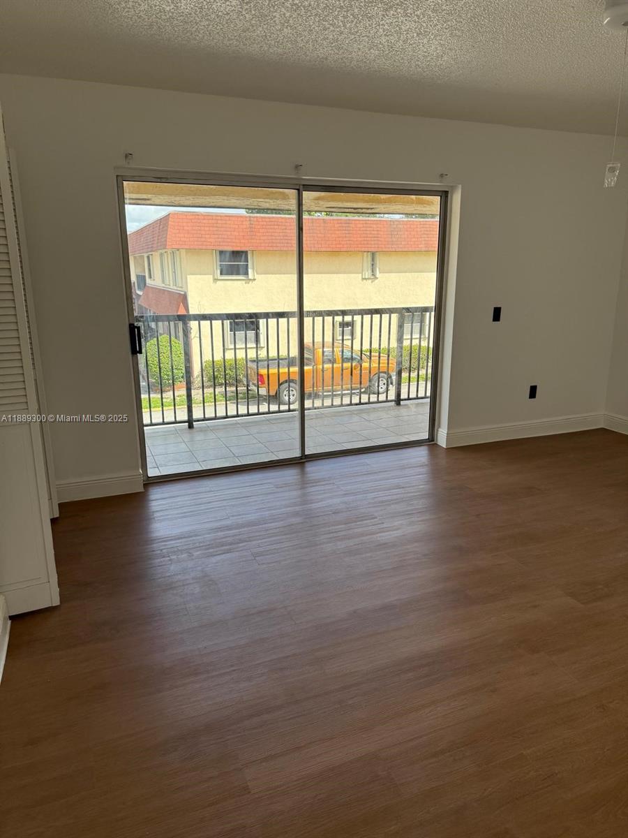 4163 Southwest 66th Terrace, Unit 108 Davie, FL 33314 - Photo 11 of 15 a view of an empty room with wooden floor and a window