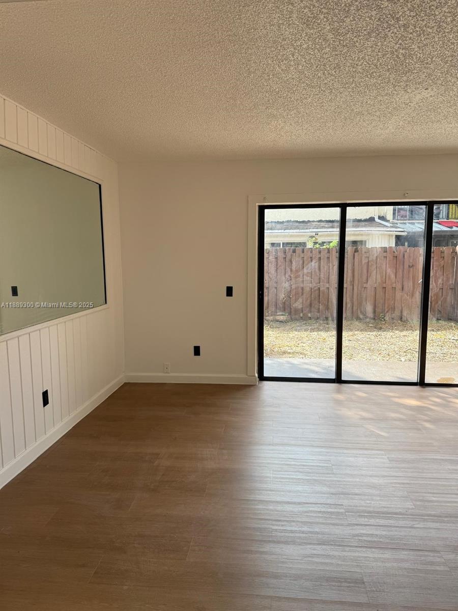 4163 Southwest 66th Terrace, Unit 108 Davie, FL 33314 - Photo 6 of 15 wooden floor in an empty room with a window