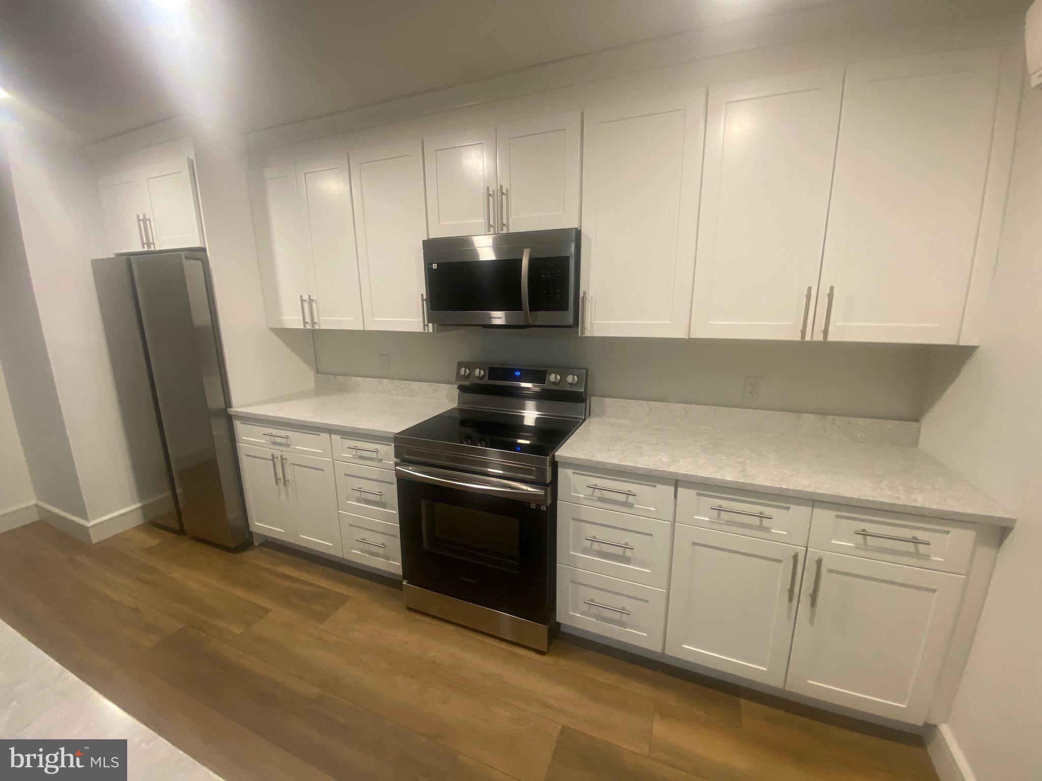 a kitchen with stainless steel appliances white cabinets and a refrigerator