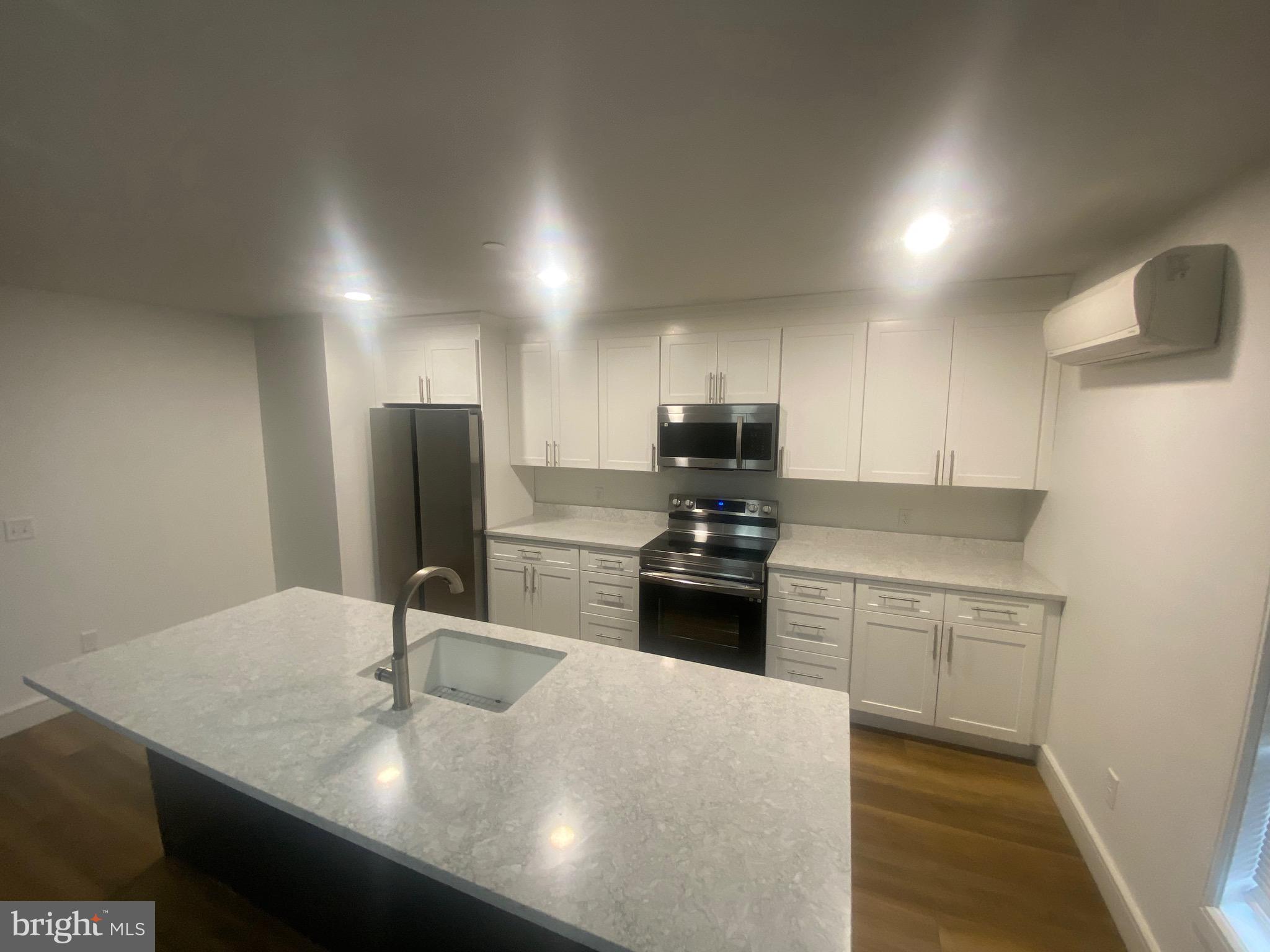 1087 Mt Tom Road, Unit 204 East Stroudsburg, PA 18301 - Photo 2 of 17 a kitchen with stainless steel appliances granite countertop a sink stove and refrigerator