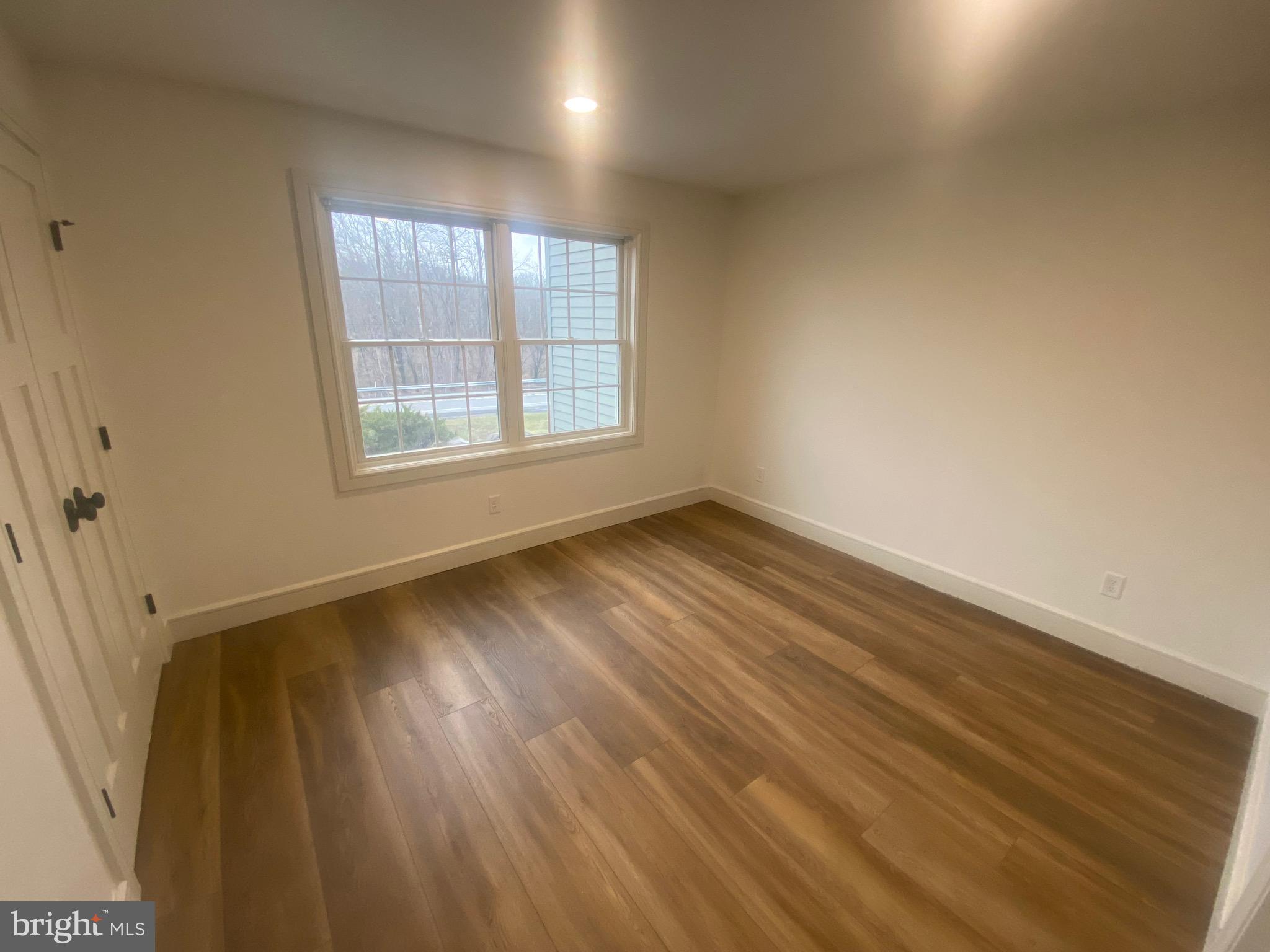 1087 Mt Tom Road, Unit 204 East Stroudsburg, PA 18301 - Photo 5 of 17 an empty room with wooden floor and windows