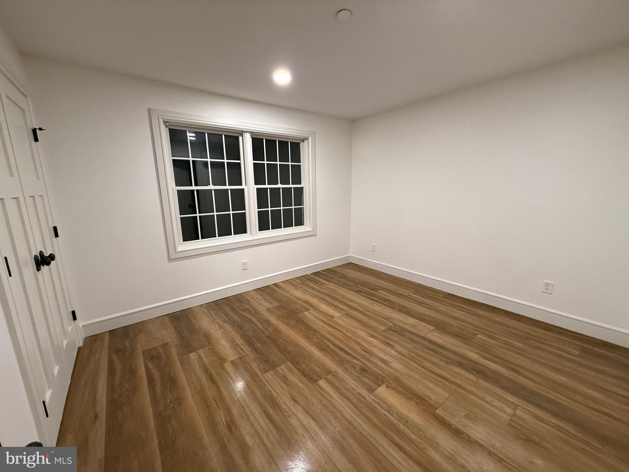 1087 Mt Tom Road, Unit 204 East Stroudsburg, PA 18301 - Photo 8 of 17 a view of an empty room with wooden floor and a window