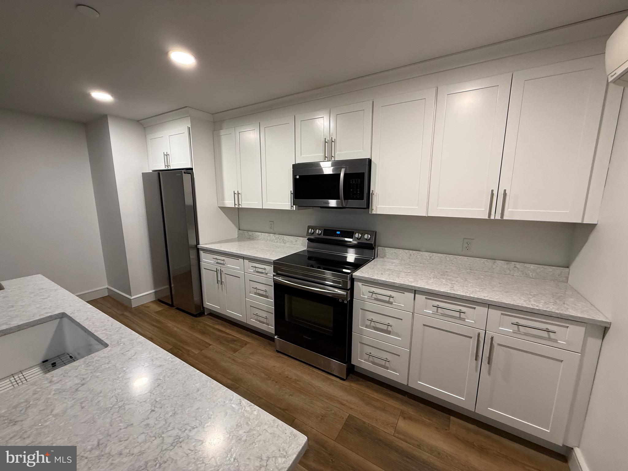 1087 Mt Tom Road, Unit 204 East Stroudsburg, PA 18301 - Photo 10 of 17 a kitchen with stainless steel appliances white cabinets and a refrigerator