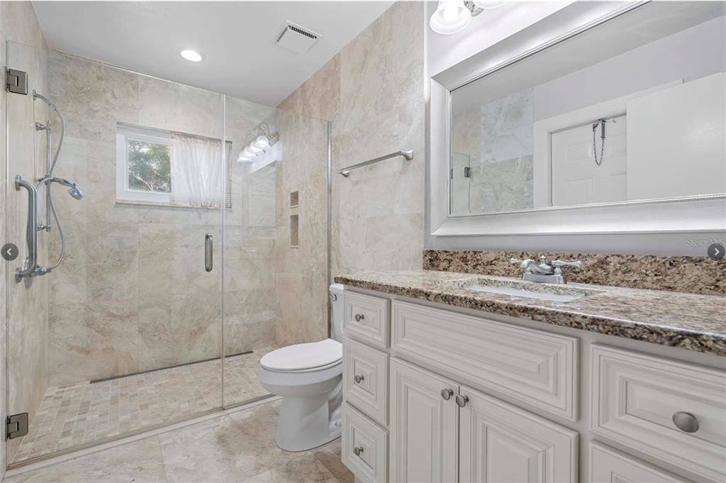 1255 Wisper Run Court Lutz, FL 33558 - Photo 13 of 25 a bathroom with a granite countertop sink a toilet and shower