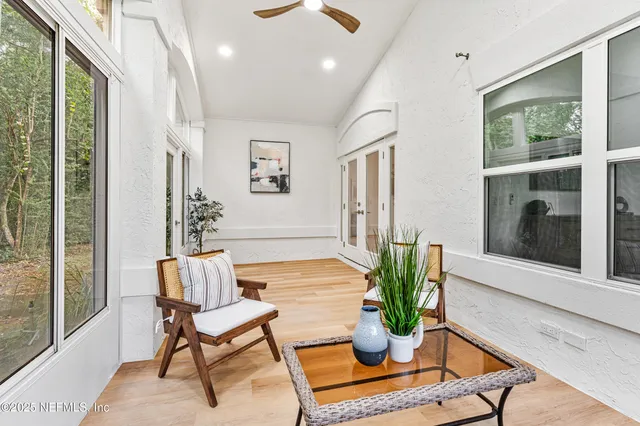 a living room with furniture potted plant and a large window