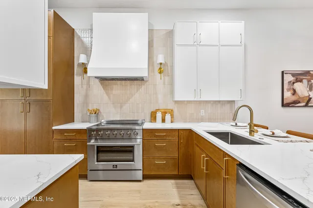 a kitchen with stainless steel appliances granite countertop a sink stove and cabinets