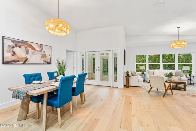 a view of a dining room with furniture a chandelier and wooden floor