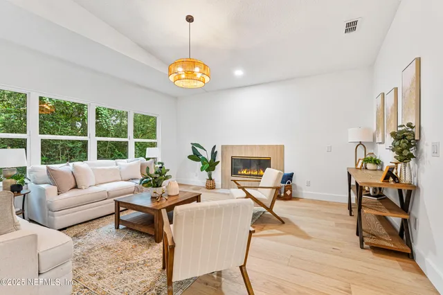 a living room with furniture a dining table and a floor to ceiling window
