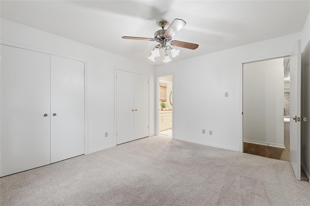 823 Ridgecrest Circle Denton, TX 76205 - Photo 27 of 40 Carpeted interior space featuring a ceiling fan with light fixture, two sets of bi-fold closet doors, and white walls