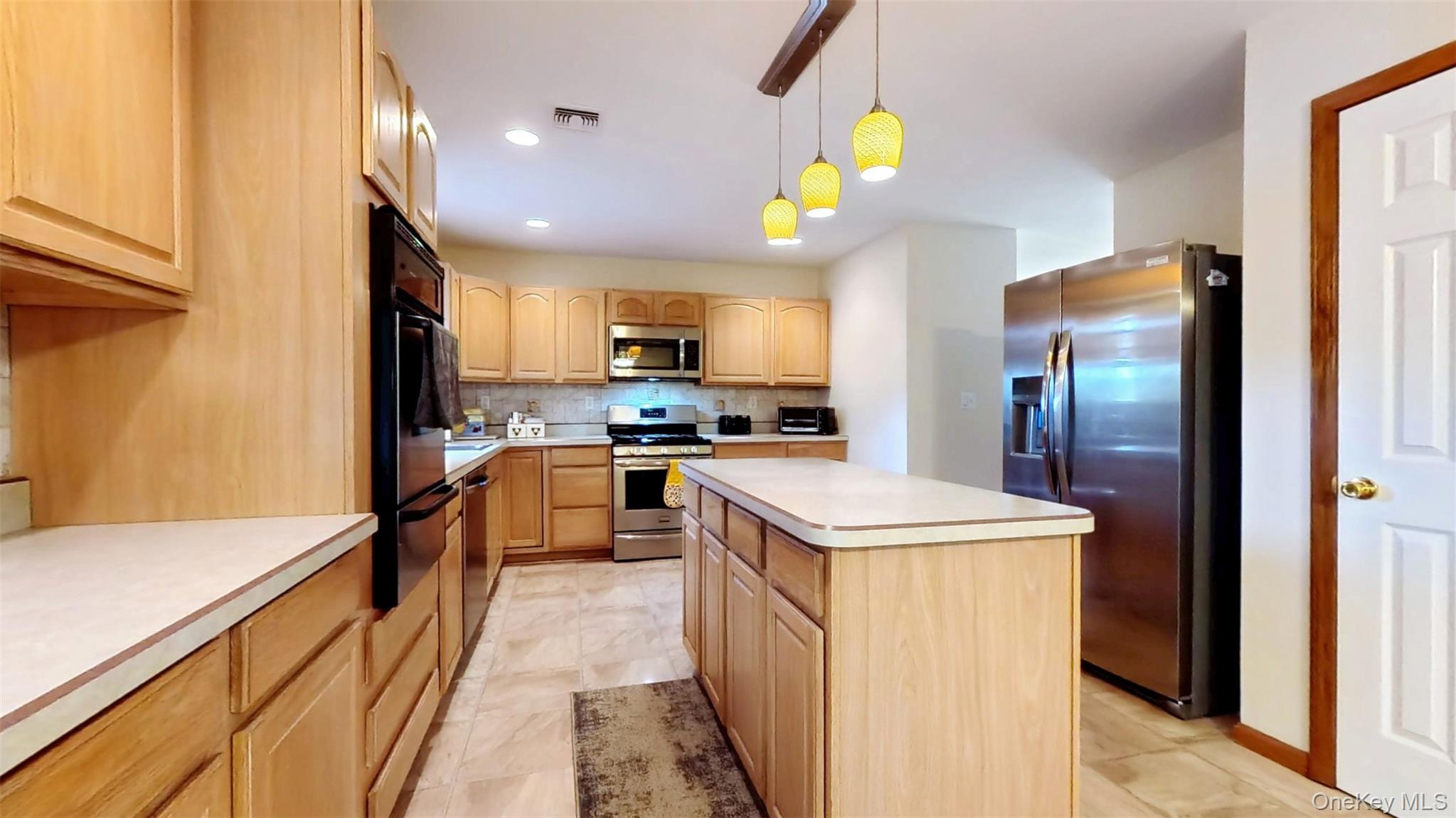 125 White Bridge Road Middletown, NY 10940 - Photo 15 of 43 Kitchen featuring stainless steel appliances, backsplash, hanging light fixtures, light countertops, and a kitchen island