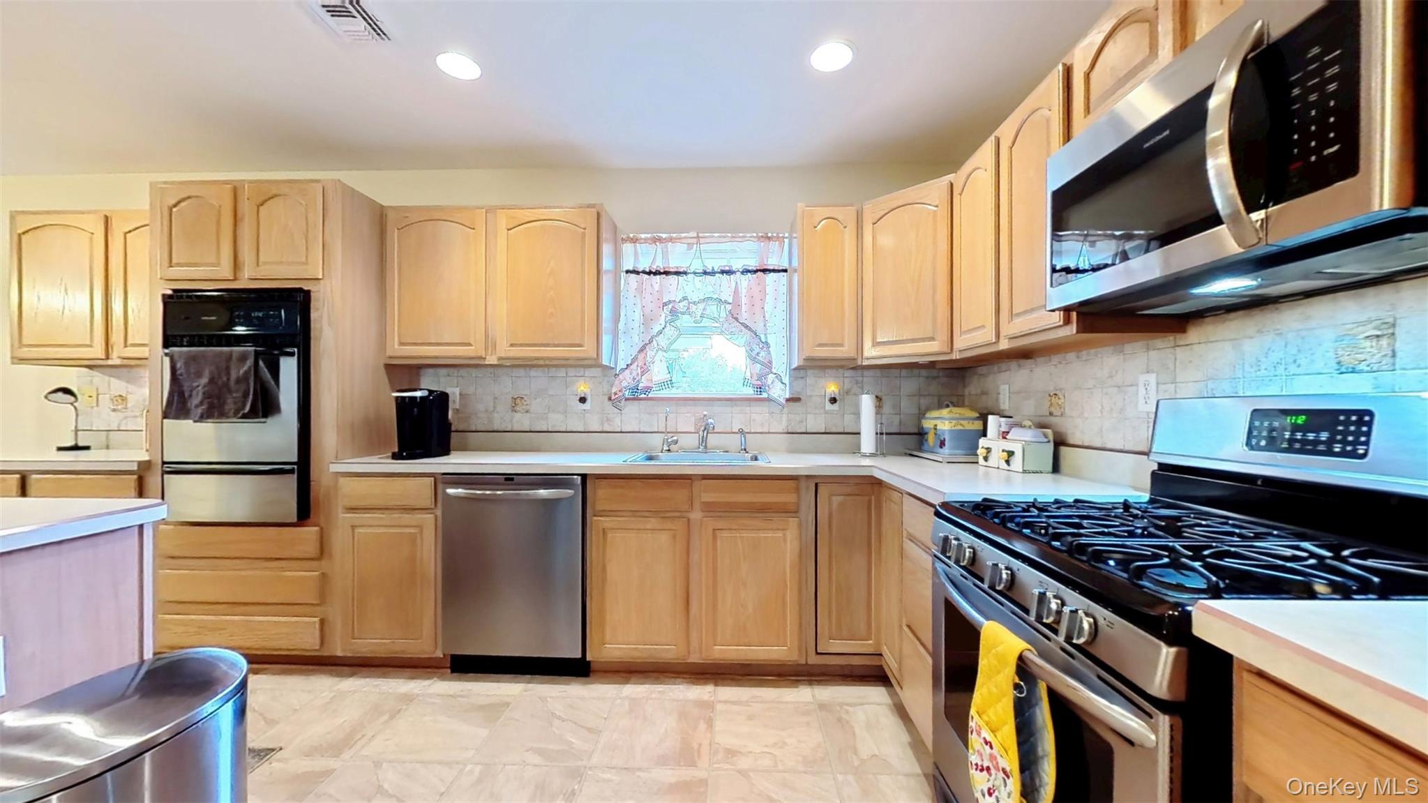 125 White Bridge Road Middletown, NY 10940 - Photo 16 of 43 Kitchen featuring appliances with stainless steel finishes, light brown cabinets, light countertops, decorative backsplash, and recessed lighting