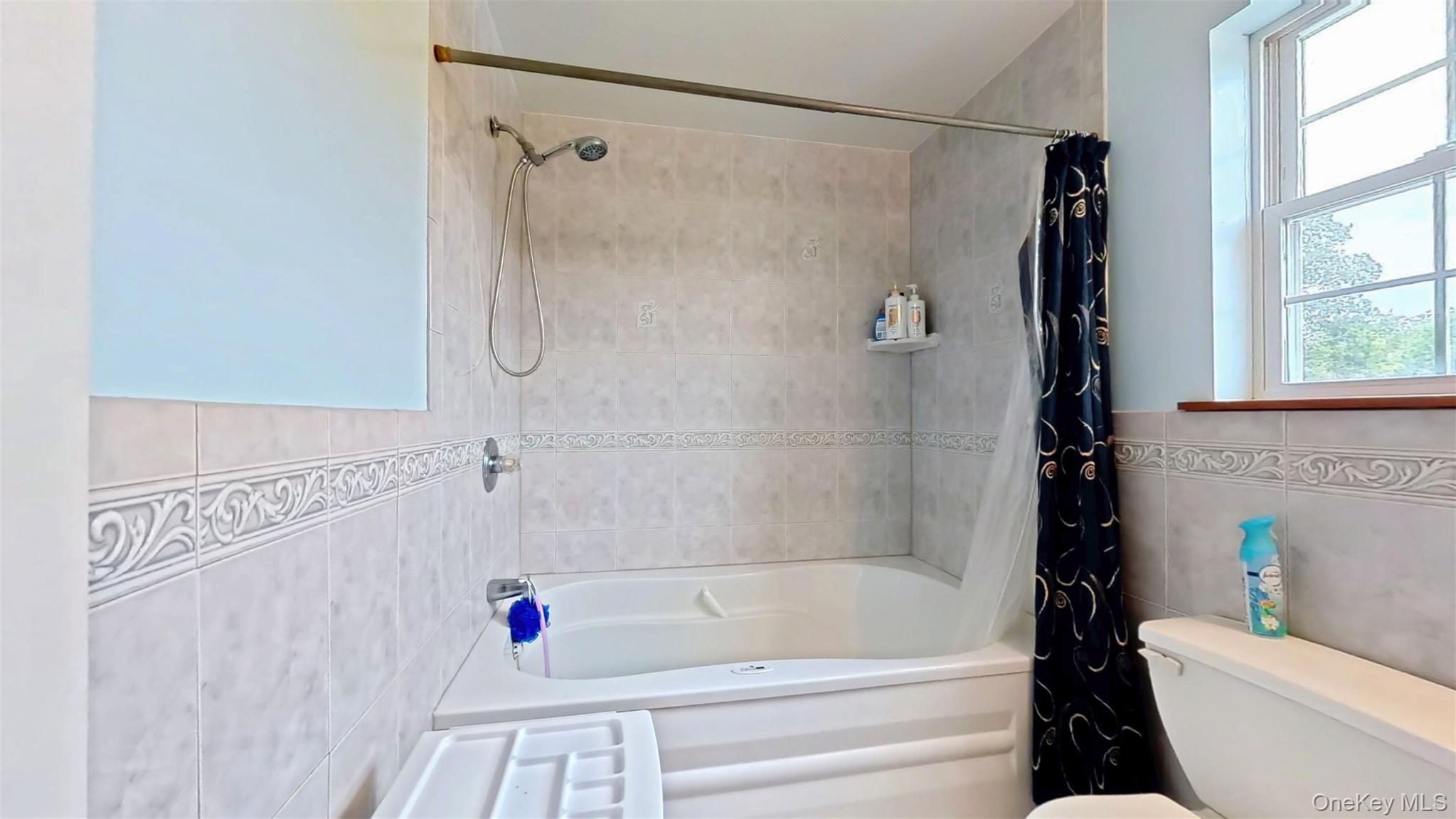 125 White Bridge Road Middletown, NY 10940 - Photo 27 of 43 Full bathroom featuring tile walls and shower / bath combo with shower curtain