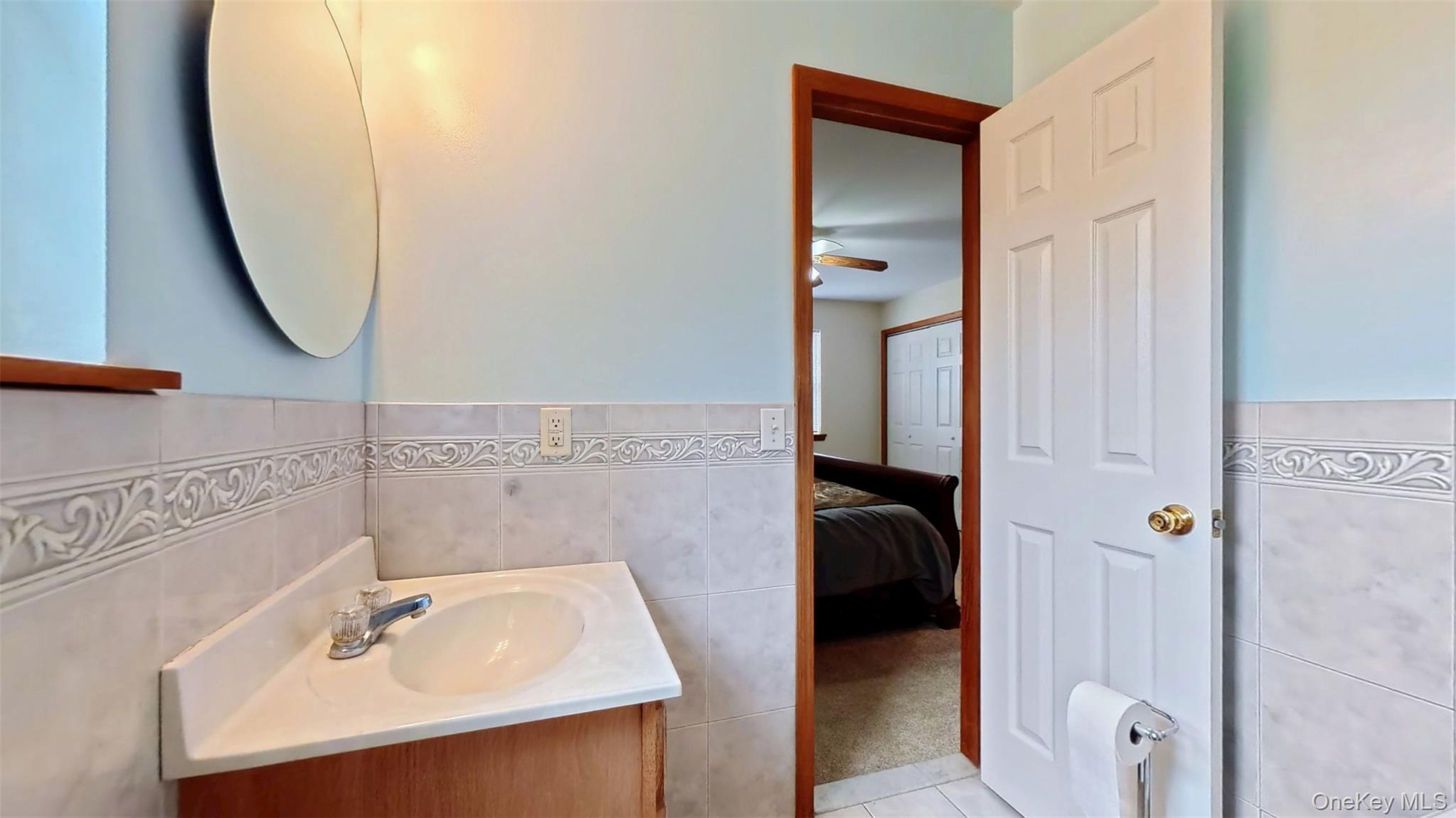 125 White Bridge Road Middletown, NY 10940 - Photo 28 of 43 Ensuite bathroom with tile walls, light tile patterned floors, vanity, and a wainscoted wall
