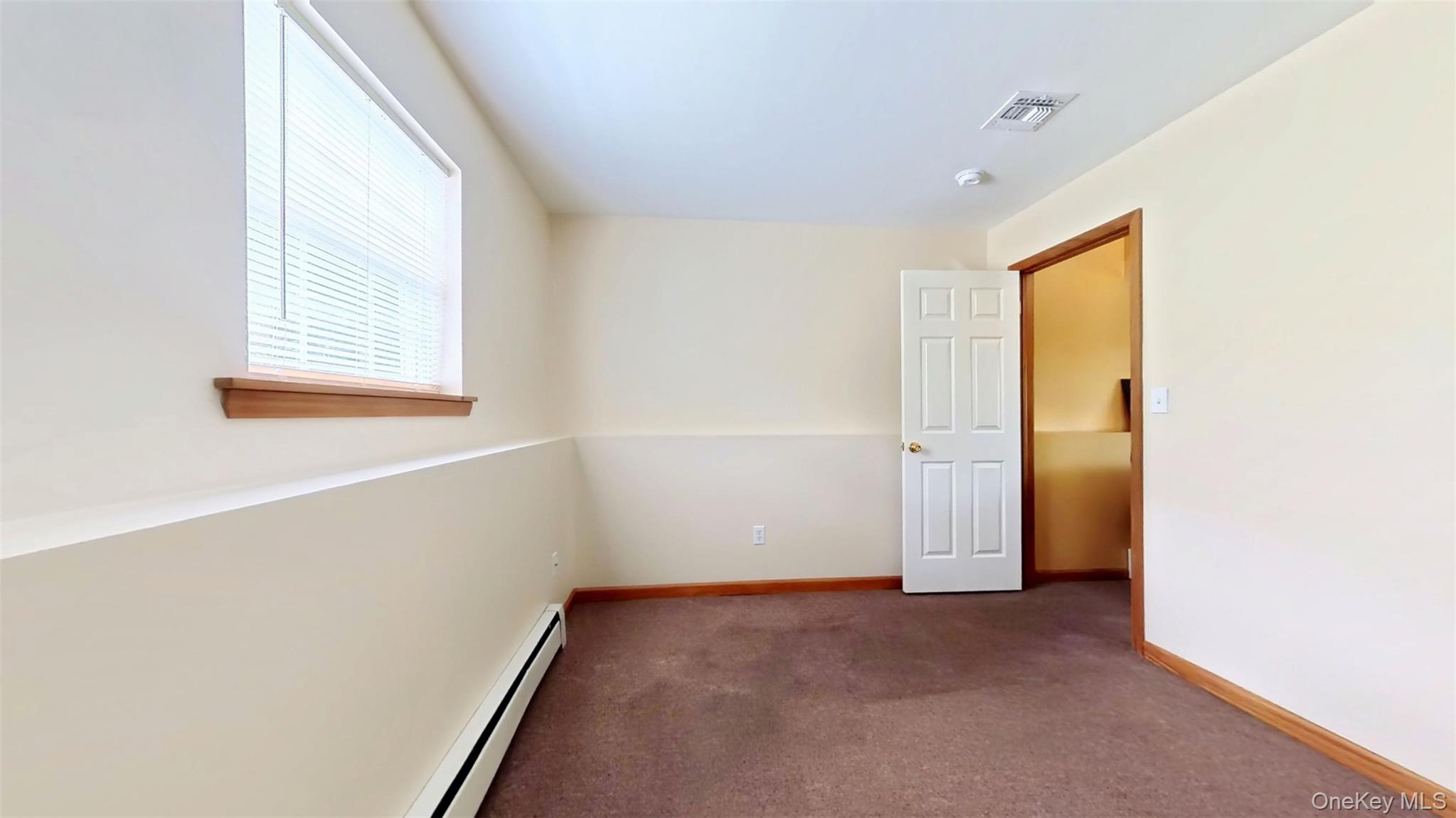 125 White Bridge Road Middletown, NY 10940 - Photo 35 of 43 Unfurnished room featuring a baseboard heating unit and dark colored carpet