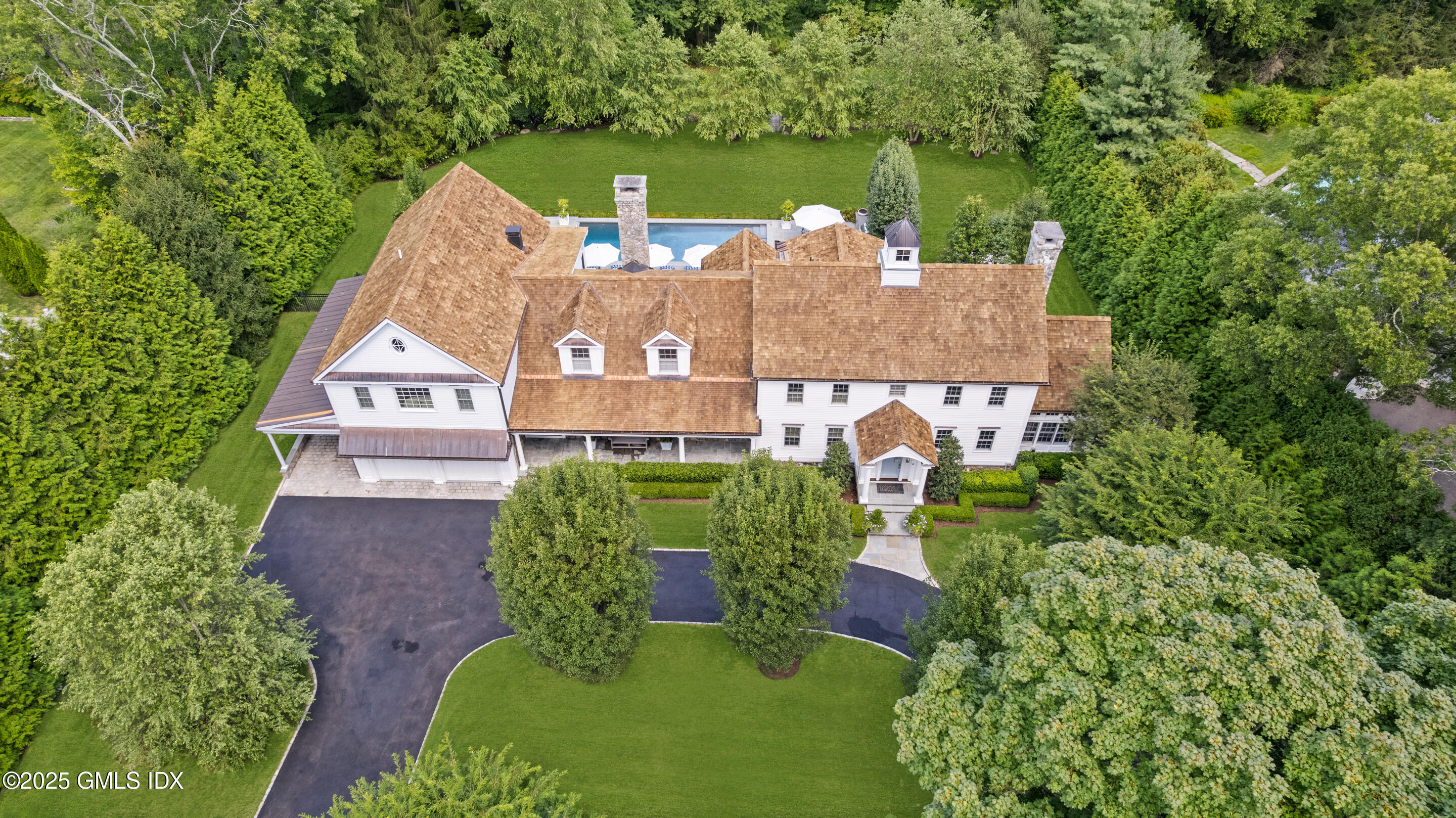 an aerial view of a house with a garden and lake view