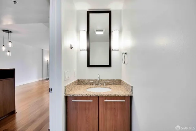 a bathroom with a granite countertop sink and a mirror