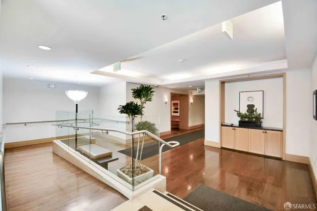 a kitchen with granite countertop a sink and white cabinets with wooden floor