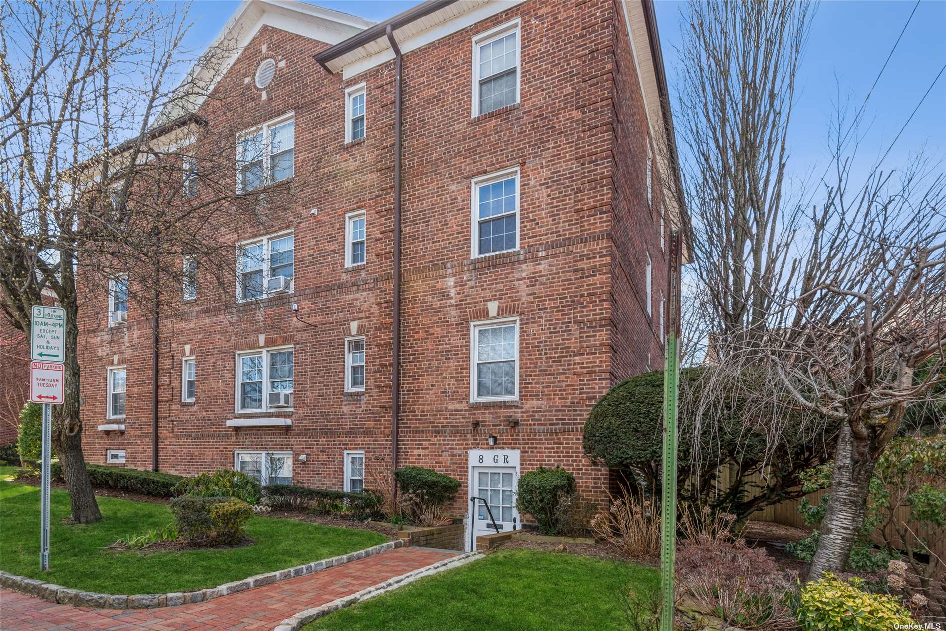 8 Welwyn Road, Unit GR Great Neck, NY 11021 - Photo 1 of 1 a view of a brick building next to a yard