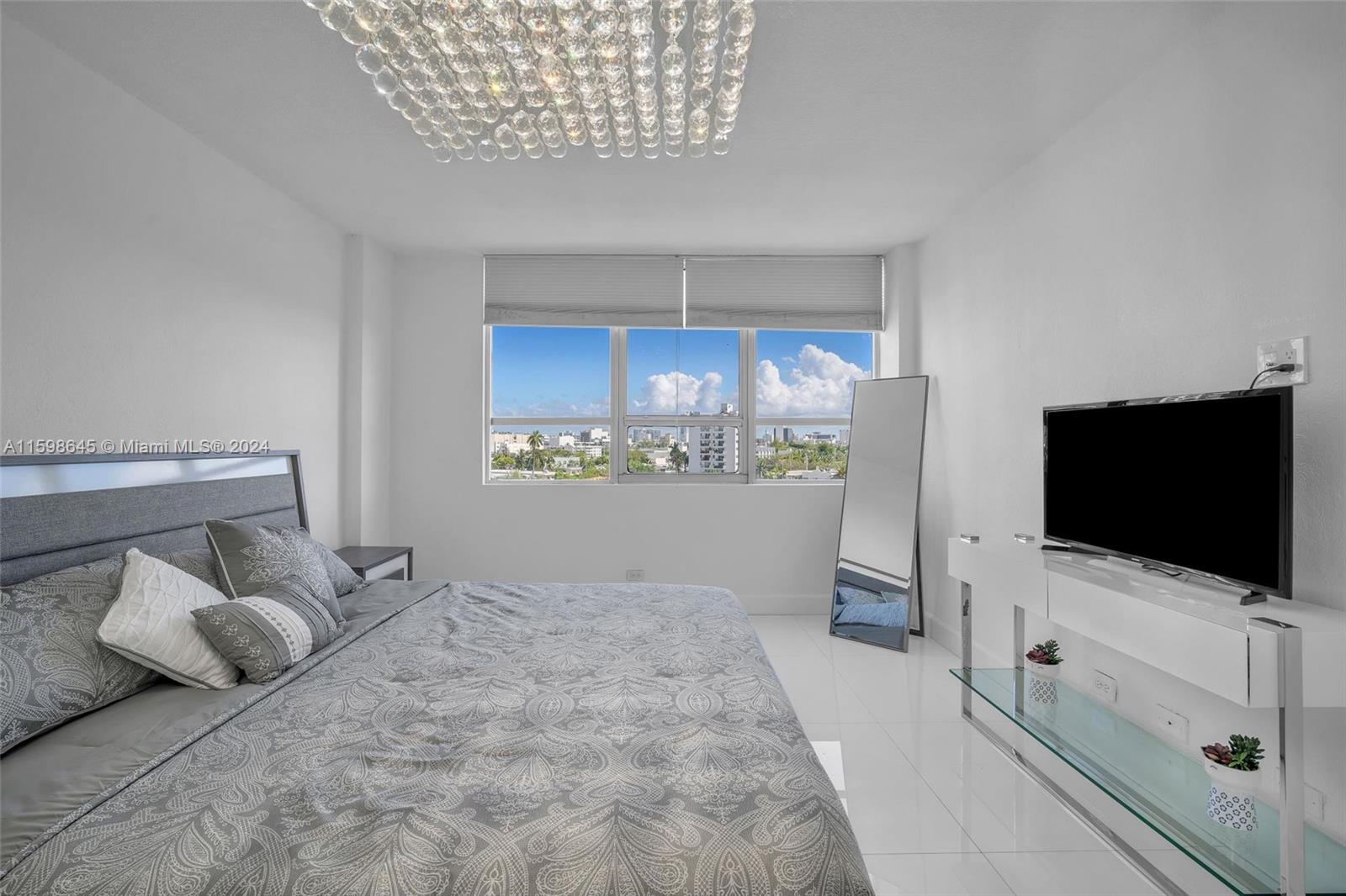1500 Bay Road, Unit 608S Miami Beach, FL 33139 - Photo 4 of 8 a bedroom with a bed and a flat screen tv