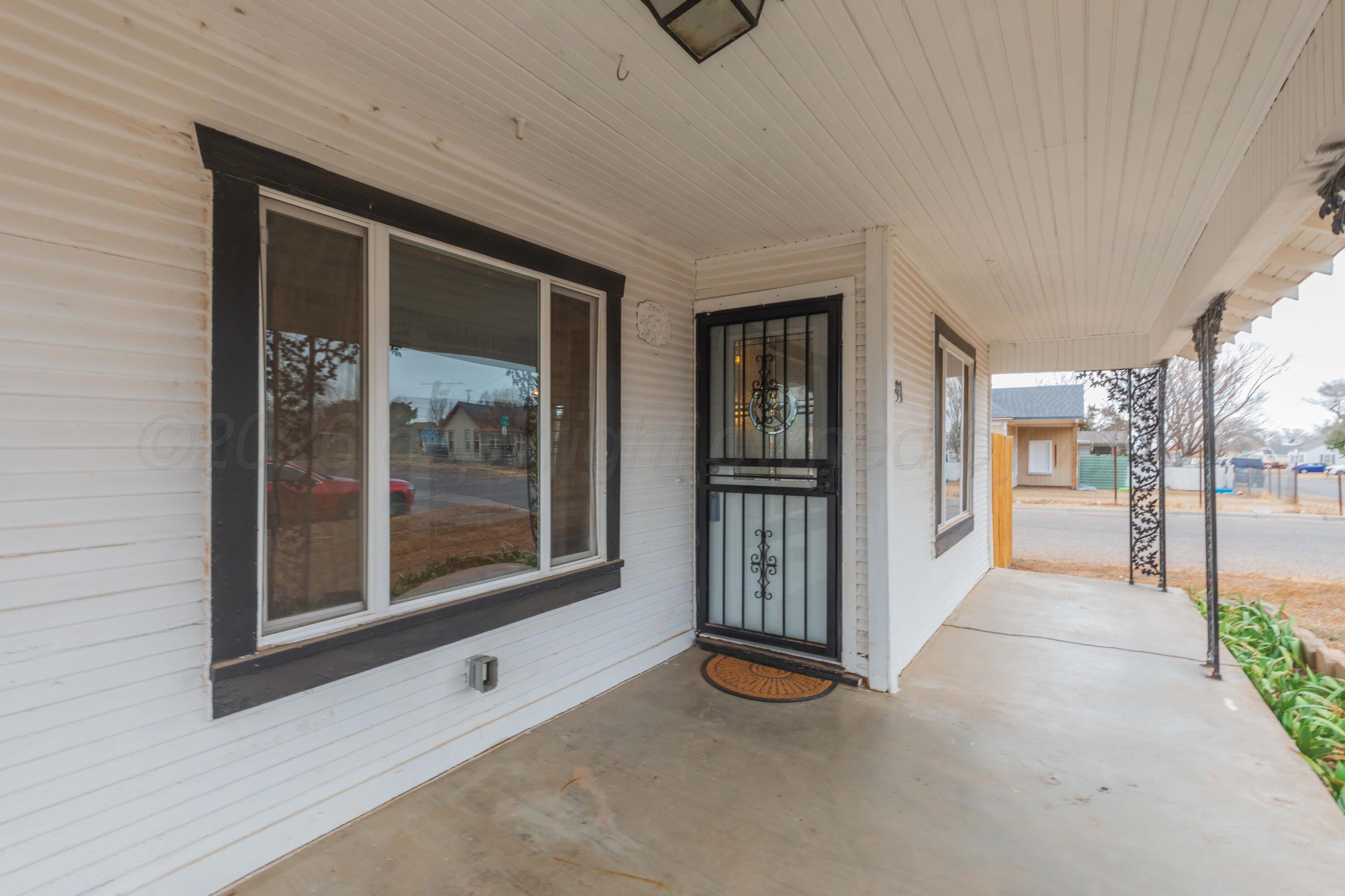 91 North Alabama Street Amarillo, TX 79106 - Photo 2 of 28 a view of empty room with floor to ceiling window and tv