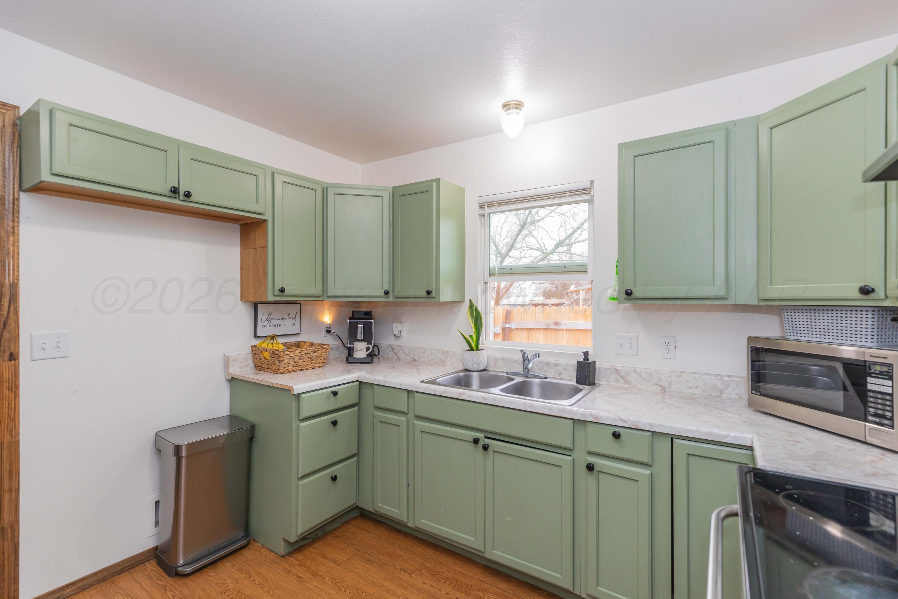 91 North Alabama Street Amarillo, TX 79106 - Photo 9 of 28 a kitchen with a sink cabinets and a microwave
