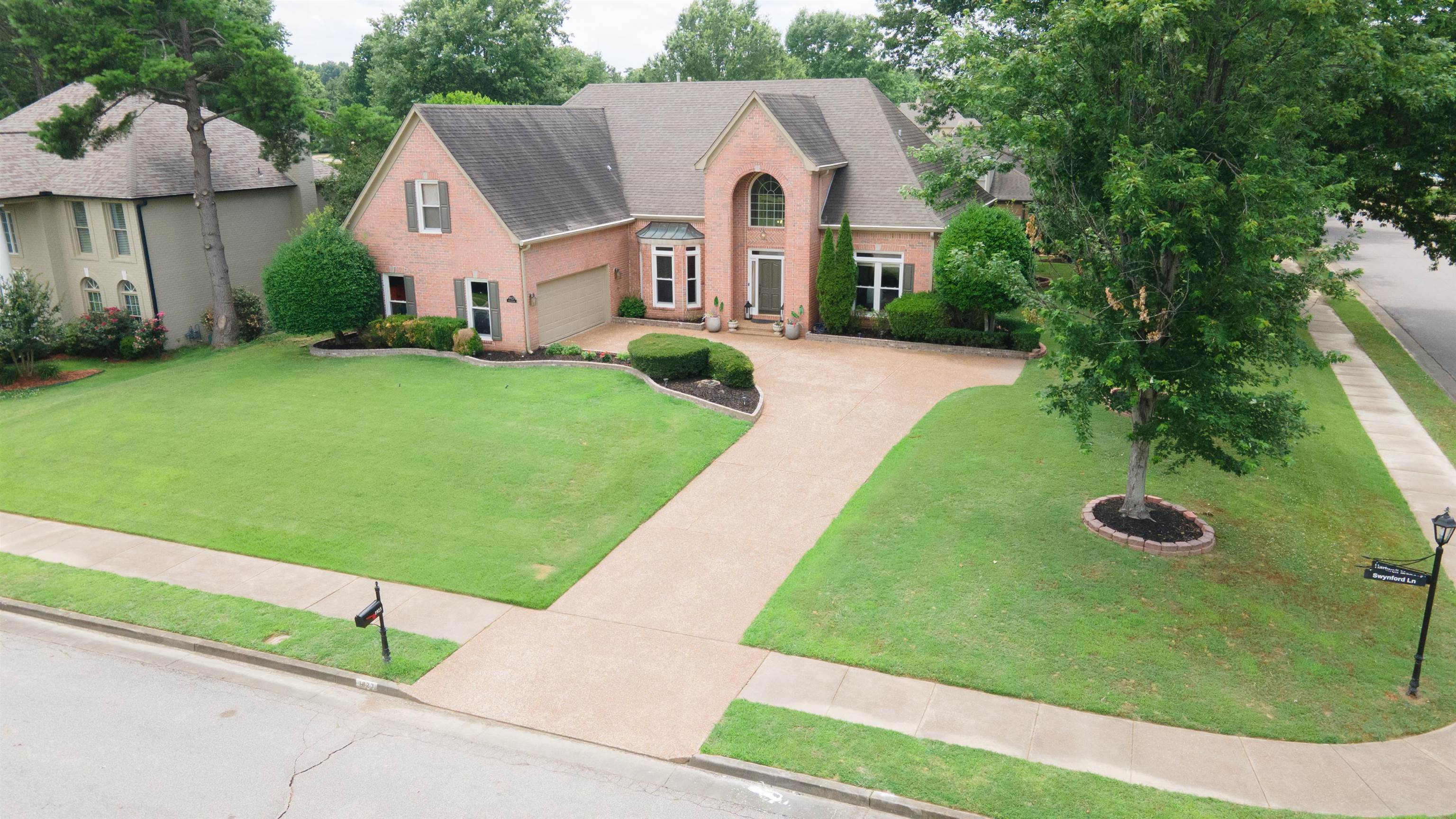 1923 Swynford Lane Collierville, TN 38017 - Photo 2 of 35 Traditional home featuring a shingled roof, driveway, a front yard, an attached garage, and brick siding